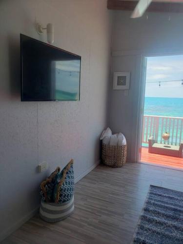 a living room with a flat screen tv on the wall at The Red Door Beach House, Buye Beach in Cabo Rojo