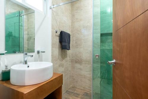 a bathroom with a sink and a glass shower at Depa Ejetutivo en Centro de Historico de DGO in Durango
