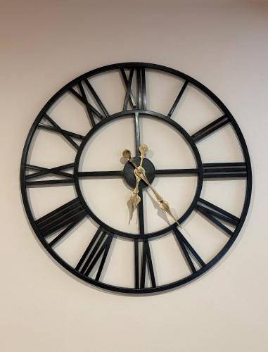a black and white clock on a wall at Birmingham City Stay Apartments in Birmingham