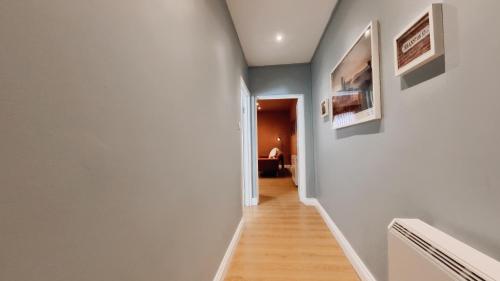 a hallway with white walls and wood floors and a room at Birmingham City Stay Apartments in Birmingham