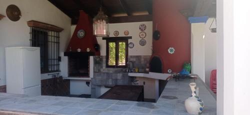 una cucina con pareti rosse e un camino in una stanza di Hacienda el chorlo a Encinarejo De Córdoba