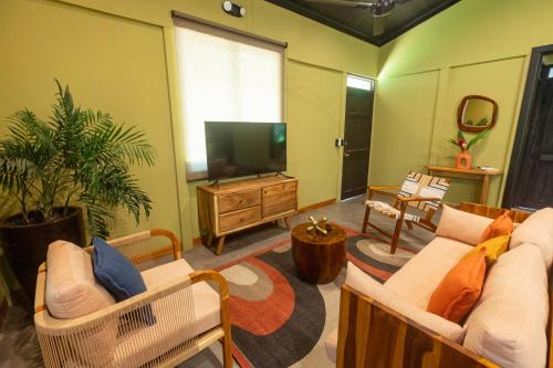 a living room with two couches and a flat screen tv at Hotel Banana Azul - Adults Only in Puerto Viejo