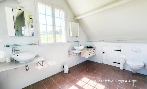 - une salle de bains blanche avec deux lavabos et deux miroirs dans l'établissement Très belle maison à 2 pas de la mer, 6 personnes, à Benerville-sur-Mer