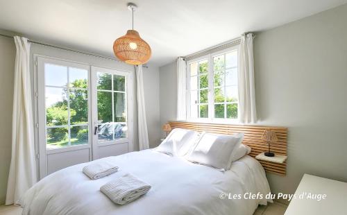 - une chambre avec un lit doté de draps blancs et de fenêtres dans l'établissement Très belle maison à 2 pas de la mer, 6 personnes, à Benerville-sur-Mer