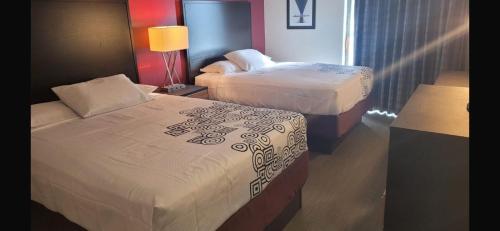 a hotel room with two beds and a lamp at Americas Best Value Inn Horseheads in Elmira