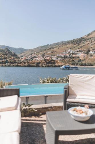 a patio with a table and chairs and a pool at Vivenda à Beira Rio in Folgosa