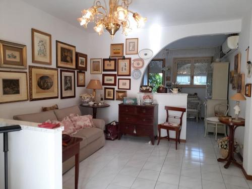 una sala de estar con sofá y muchas fotos en la pared en La casa di Gaga - Appartamento nel Chianti senese, en Ponte A Bozzone