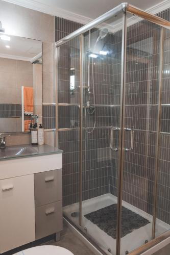 a shower stall in a bathroom with a sink at Vivenda à Beira Rio in Folgosa