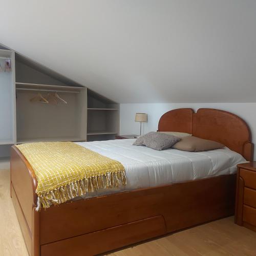 a bedroom with a large bed with a wooden headboard at Maria's House in Câmara de Lobos