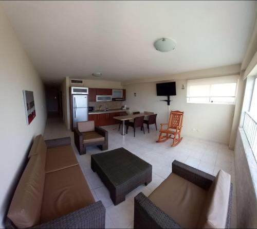 ein Wohnzimmer mit Couch und Tisch und eine Küche in der Unterkunft Apartamento con vista al Mar y salida a la playa in Tucacas