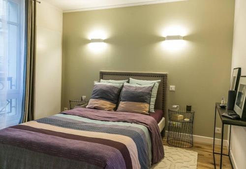 - une chambre avec un lit et deux lumières sur le mur dans l'établissement Cosy flat Paris 14, à Paris