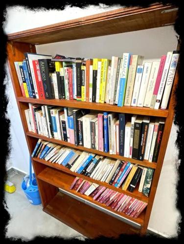 a book shelf filled with lots of books at Vue Mer Panoramique, Grande Terrasse Privée, Plage à 10 Min in Sainte-Anne