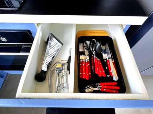 a drawer filled with utensils in a cabinet at Vue Mer Panoramique, Grande Terrasse Privée, Plage à 10 Min in Sainte-Anne