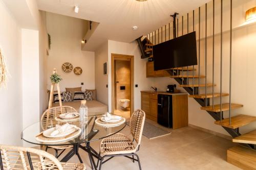a dining room with a table and chairs and a television at ADORNO PRIVATE SUITES Only Adults & Kids 12 Plus in Nea Vrasna