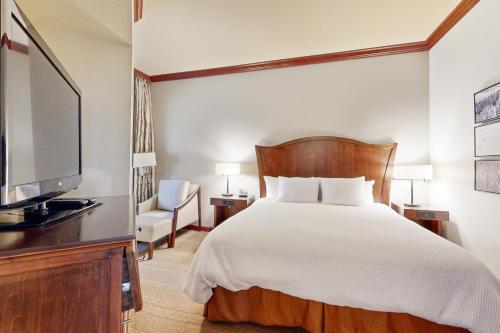 a bedroom with a bed and a flat screen tv at Resort at Squaw Creek's 128 in Olympic Valley