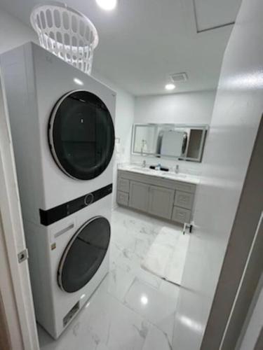 a white bathroom with a sink and a microwave at Charming Family Retreat in Augusta