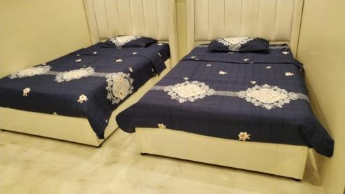 two beds sitting next to each other in a bedroom at شالية السحاب in Al Ḩazm