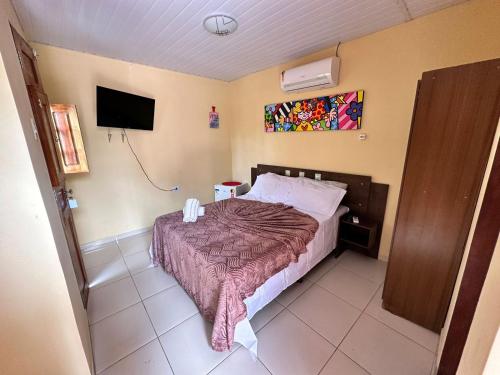 a bedroom with a bed and a flat screen tv at Pousada do Gord0 in Bonito