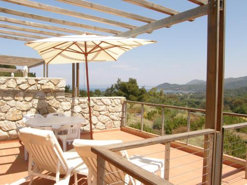 a patio with a table and chairs and an umbrella at Allegroitalia Elba Golf in Portoferraio
