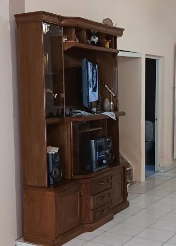 a large wooden entertainment center with a tv in it at Casa Familiar "Chiqui" in Cochabamba