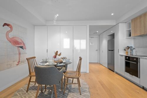 a kitchen and dining room with a table and chairs at Complete Host STK Apartments in Melbourne