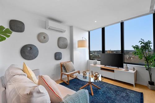 a living room with a couch and a tv at Complete Host STK Apartments in Melbourne