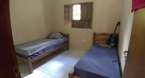a small room with two beds and a window at Casa na Serra in Bezerros