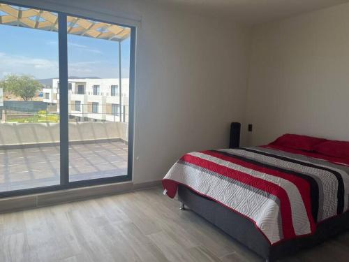 a bedroom with a bed and a large window at Casa Cordova in Alpuyeca