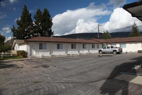 a building with a truck parked in a parking lot at Ranchland Villa Motel in Merritt