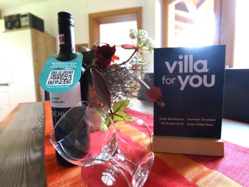 a bottle of wine and a wine glass on a table at Wildauer in Strass im Zillertal