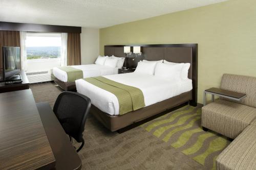 a hotel room with two beds and a couch at Holiday Inn Wilkes Barre - East Mountain, an IHG Hotel in Wilkes-Barre
