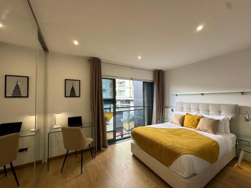 Un dormitorio con una cama grande y un balcón. en Living Funchal V, en Funchal