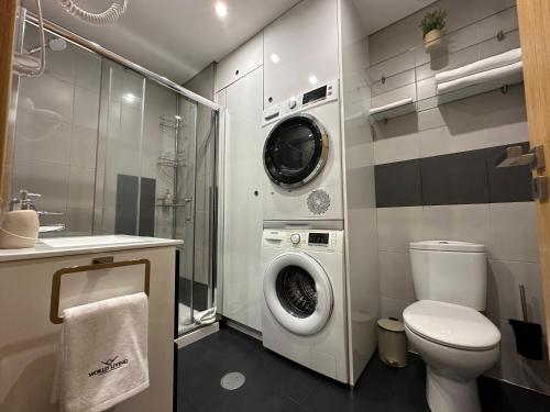 Un baño con inodoro y lavadora. en Living Funchal V, en Funchal