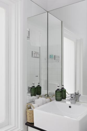 a white bathroom with a sink and a mirror at MAC St Kilda Acland St by Melbourne Apartment Collection in Melbourne