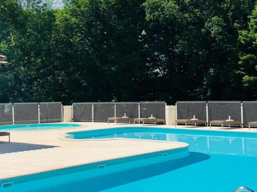une piscine avec deux chaises et une clôture dans l'établissement Le Lac Bleu nr 27, à Lacapelle-Marival