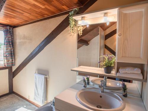 Habitación con techo de madera y baño con 2 lavabos. en Gite Les Terrasses, en Prats-du-Périgord