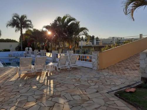 a group of chairs and a dog sitting on a patio at Recanto Serenissima in São Pedro