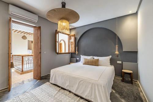 a bedroom with a white bed and a blue wall at Riad Macan Exclusive and Trendy Chich Breakfast incl in Marrakech