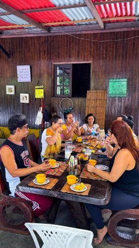 a group of people sitting around a wooden table at Floresta Zen - Pousada Xamanica in Manaus