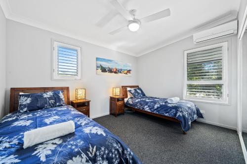 a bedroom with two beds and two windows at Beachside by Discover Stradbroke in Point Lookout