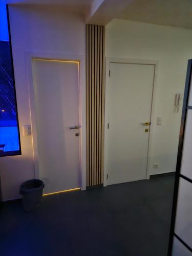 an empty room with two doors and a window at La Suite Gold Jacuzzi in Seraing