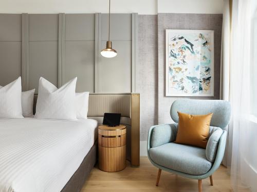 a hotel room with a bed and a chair at The Porter House Hotel Sydney - MGallery in Sydney