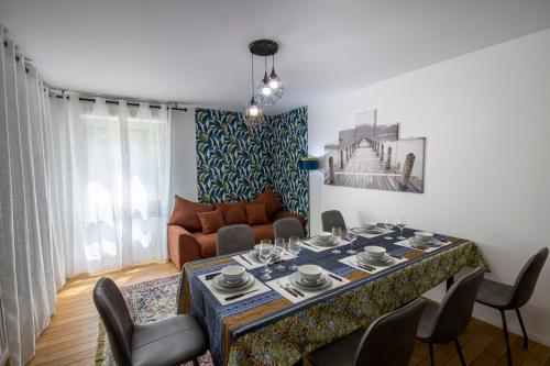 un salon avec une table avec des chaises et un canapé dans l'établissement Appartement cosy aux portes de Paris - 10 pers, à Aubervilliers