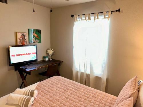 a bedroom with a bed and a television and a window at Retro Place - 2 bedroom & 1 bathroom - GREAT VALUE in Eagle Pass