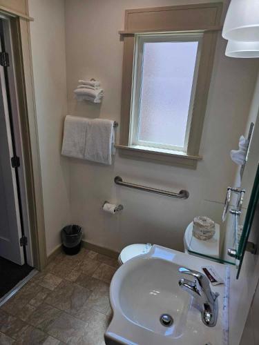 a bathroom with a white sink and a window at El Rancho Motel in Williams