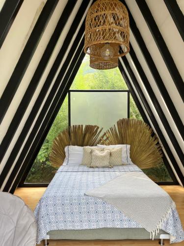 a bed in a room with a large window at Intrepido Glamping in Chinchiná
