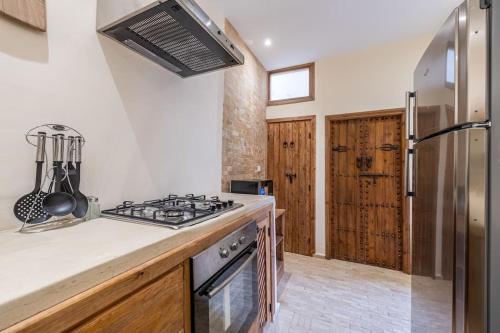 a kitchen with a stove and a refrigerator at Riad Zatiah Exclusive and chic breakfast incl in Marrakech