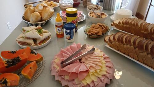 a table with many different types of food on it at Belo quinto Styles pousada in Brotas