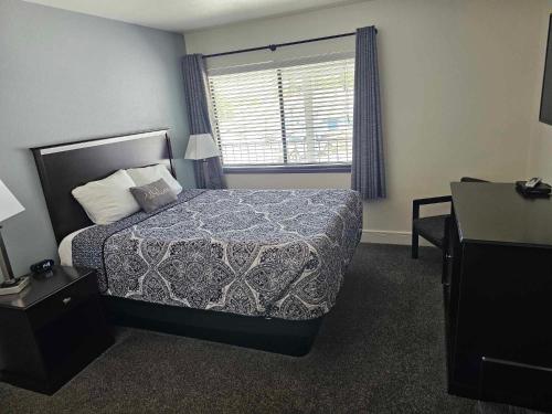 a hotel room with a bed and a window at El Rancho Motel in Williams