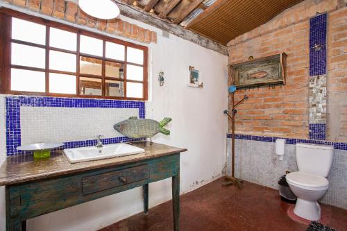 a bathroom with a sink and a toilet at Pousada Encanto das Águas in Ilhabela